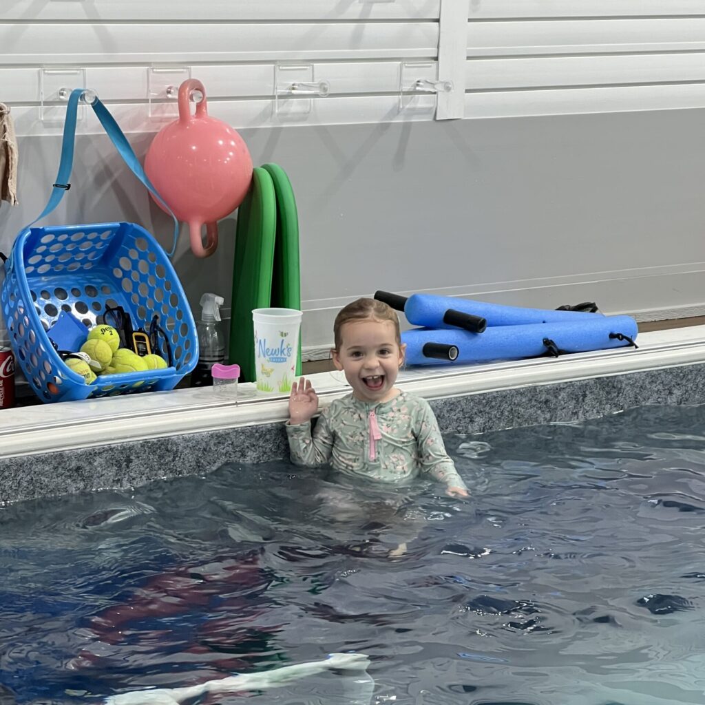 A picture of a young girl swimmer from Thistledown Swim Academy waving